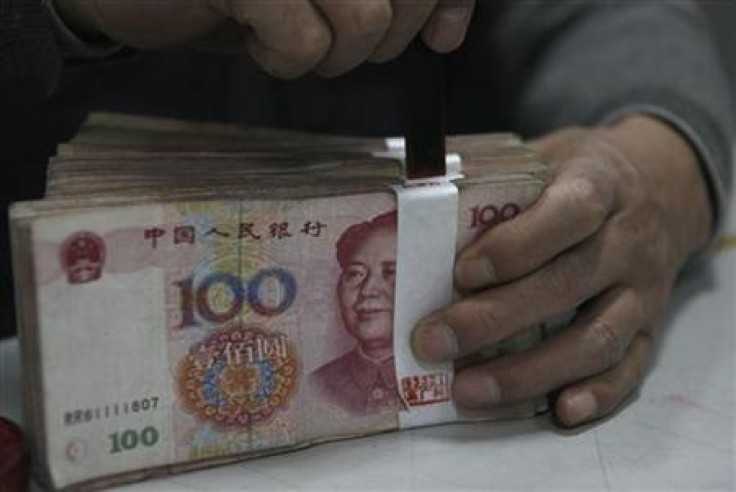 An employee seals a stack of yuan banknotes