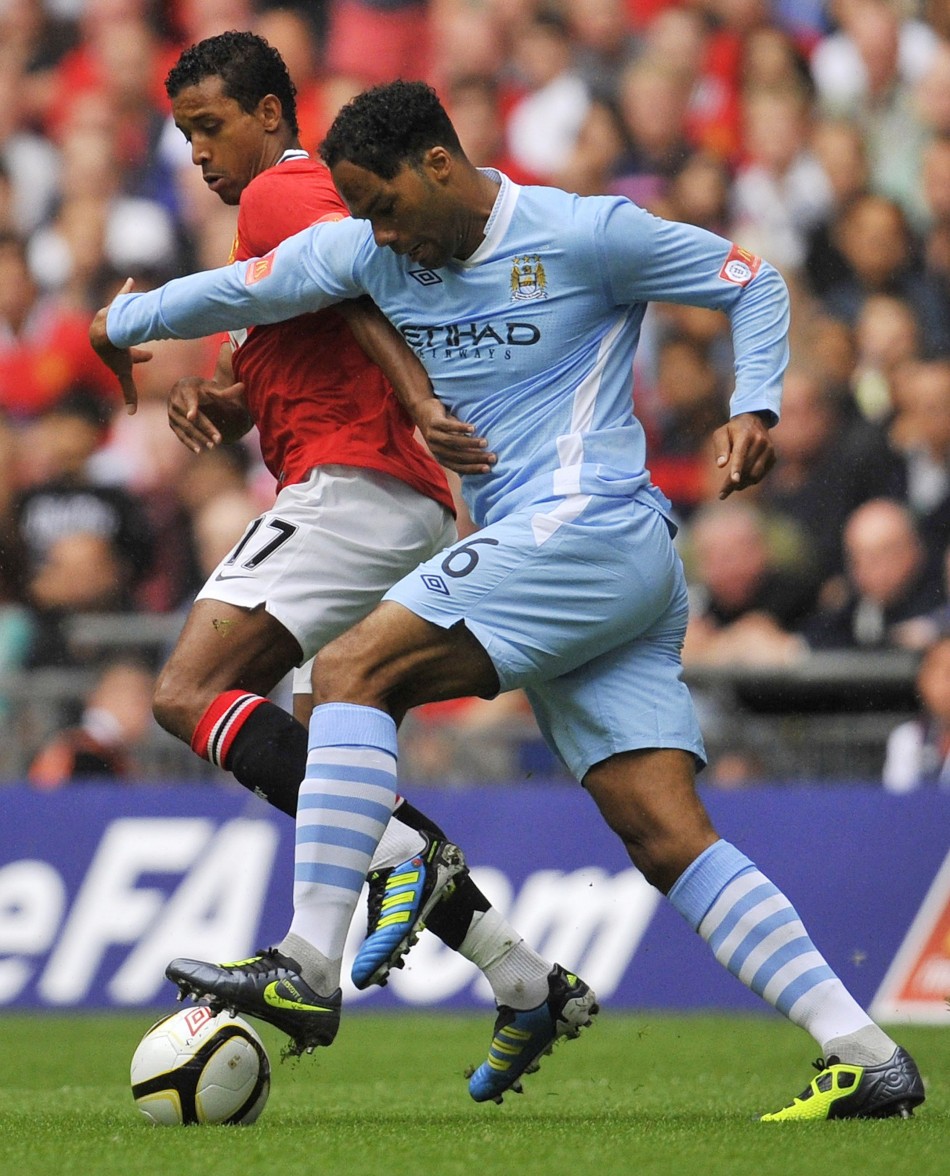Manchester Uniteds Nani is challenged by Manchester Citys Joleon Lescott during their FA Community Shield soccer match at Wembley Stadium in London