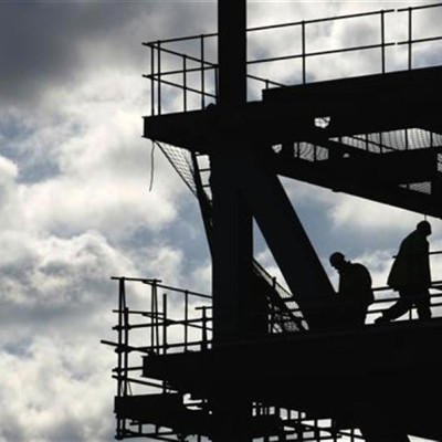 Workers are silhouetted on a construction site in London