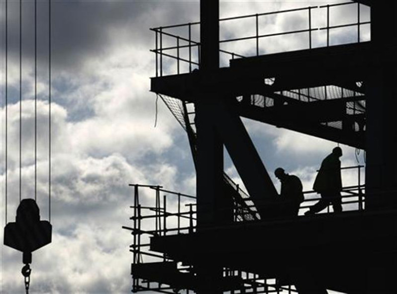 Workers are silhouetted on a construction site in London