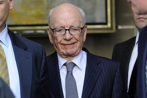 News Corp Chief Executive Rupert Murdoch is escorted out of a hotel where he met the familly of murdered teenager Milly Dowler in central London