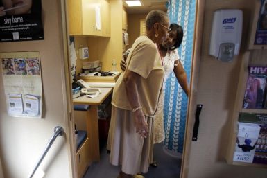 Healthcare educator Rainelle White (rear) checks the weight of client Norma Ferguson in the Family Van in Boston
