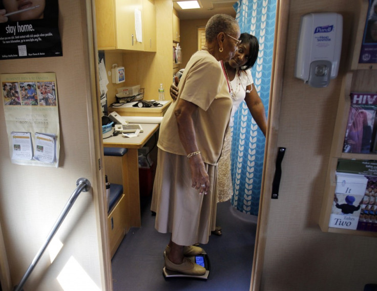 Healthcare educator Rainelle White (rear) checks the weight of client Norma Ferguson in the Family Van in Boston