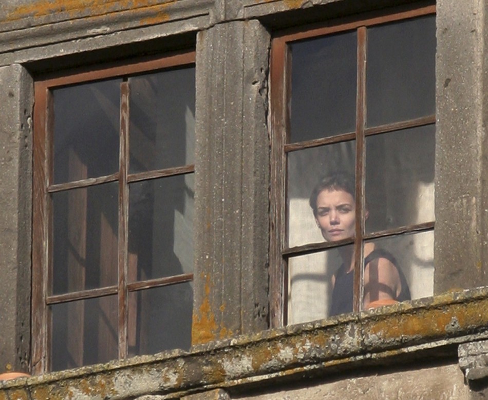 Actress Katie Holmes watches from a window of Castello Odescalchi as her fiance Tom Cruise arrives for their wedding in Bracciano