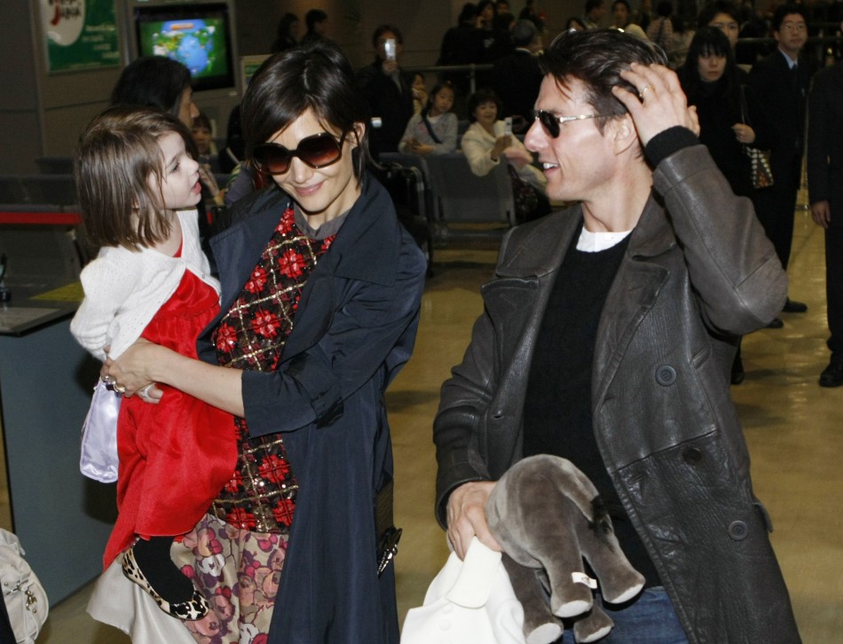 Actor Tom Cruise speaks with his daughter Suri, who is held by her mother Katie Holmes, upon their arrival at Narita international airport in Narita