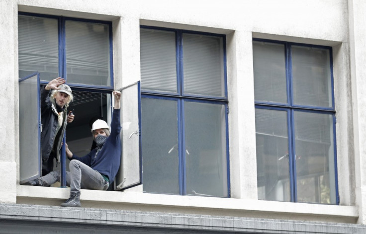 Protesters from the Occupy movement stand at the windows of one of several buildings in a quadrangle owned by banking giant UBS