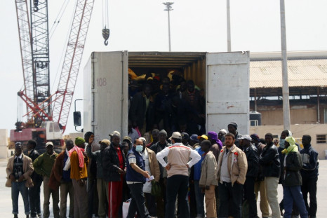 Migrant workers from Africa step out of a truck after arriving in a port in Misrata during an evacuation operation organized by IOM