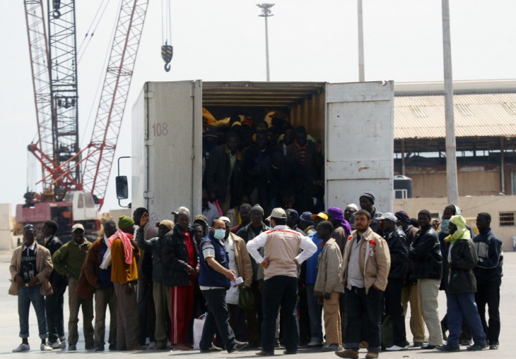 Migrant workers from Africa step out of a truck after arriving in a port in Misrata during an evacuation operation organized by IOM