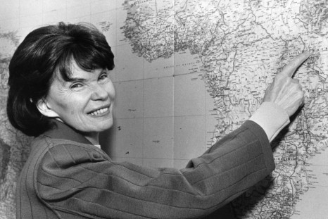 Danielle Mitterrand, the widow of former French President Mitterrand, points to a point in Kenya on a map of the world in her Paris office