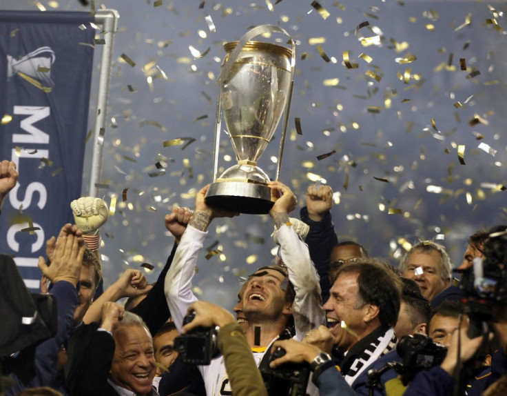 David Beckham hoists the championship trophy as the team celebrate their victory over the Houston Dynamo during their MLS Cup soccer final
