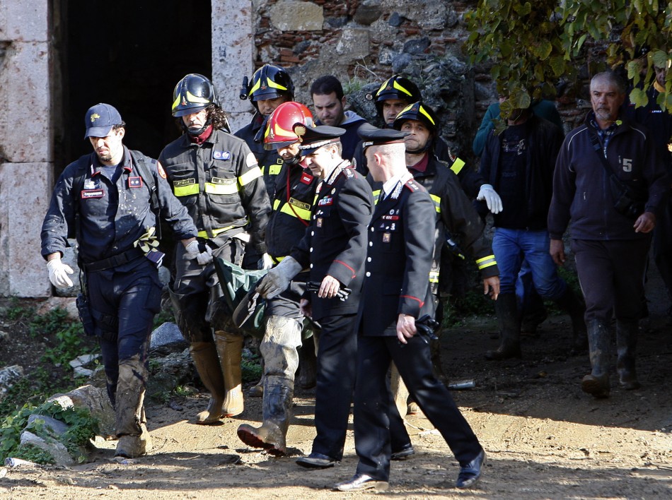 Firefighters and Carabinieri carry the body of a 10-year old boy at Scarcelli, a district of Saponara, in the province of Messina, in Sicily November 23, 2011.