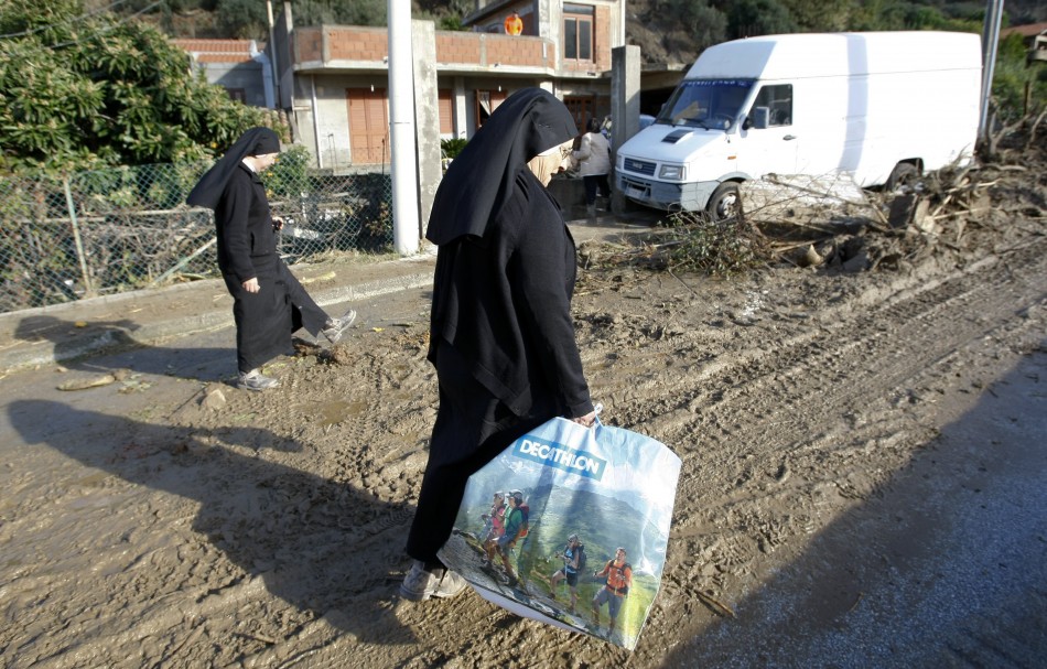 Nuns walk in the mud following a landslide at Scarcelli, a district of Saponara, in the province of Messina, in Sicily November 23, 2011