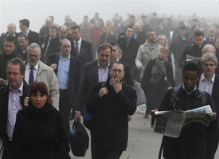 Commuters make their way in the fog across London Bridge towards the financial district of London