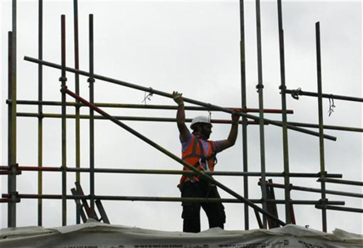 A worker takes down scaffolding on a construction site in London
