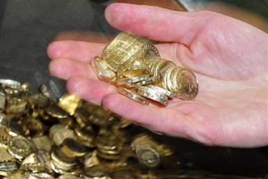 Chancellor George Osborne handles newly minted one pound coins during a visit to the Royal Mint in Cardiff