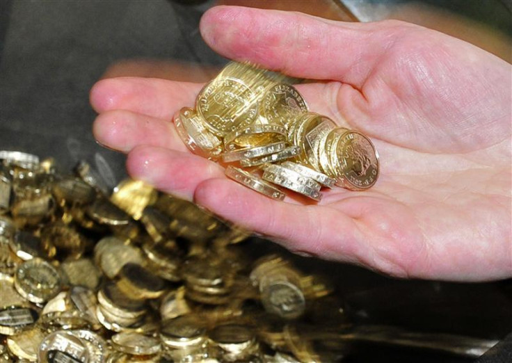 Chancellor George Osborne handles newly minted one pound coins during a visit to the Royal Mint in Cardiff