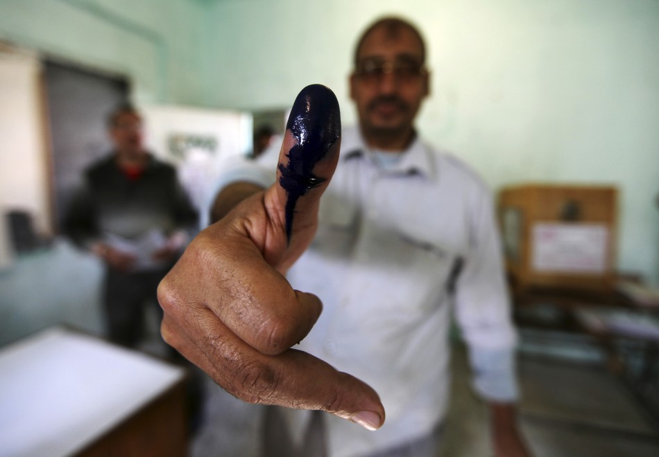 A man shows his ink stained finger after casting his vote at a polling station during parliamentary elections in Cairo