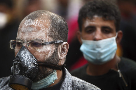 Protesters, with medical cream applied to their faces to protect against tear gas, wear surgical and gas masks during clashes near Tahrir Square