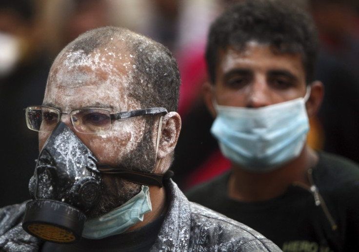 Protesters, with medical cream applied to their faces to protect against tear gas, wear surgical and gas masks during clashes near Tahrir Square