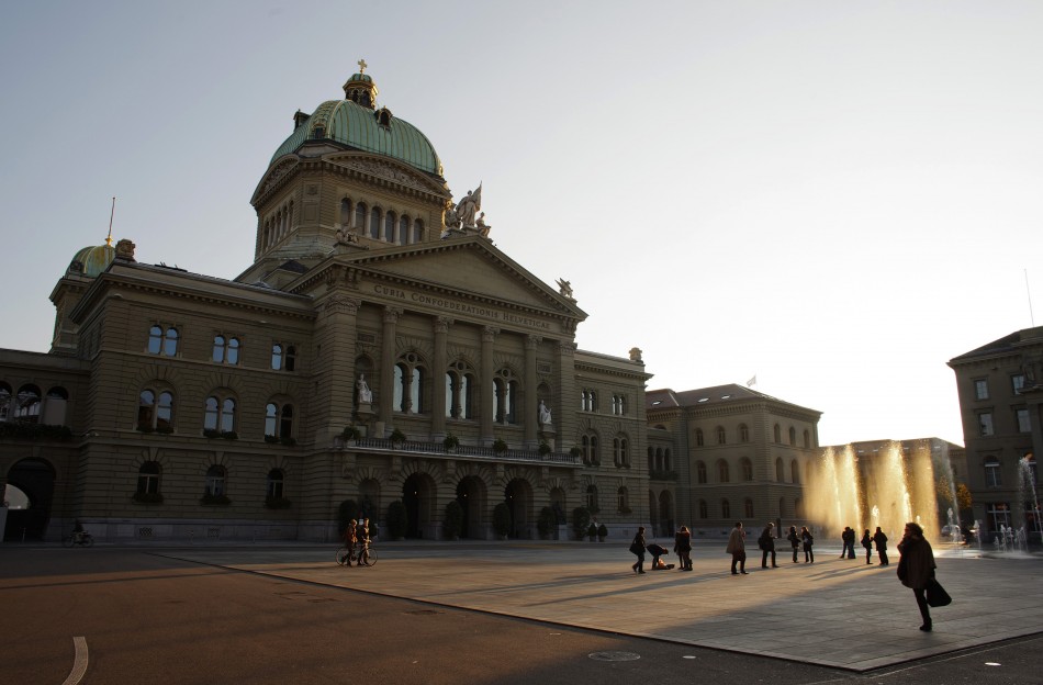 People walk around the Swiss Federal Palace Bundeshaus in Bern