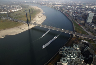Ships pass the Rhine river with a partially dried-up riverbed in the western town of Dusseldorf