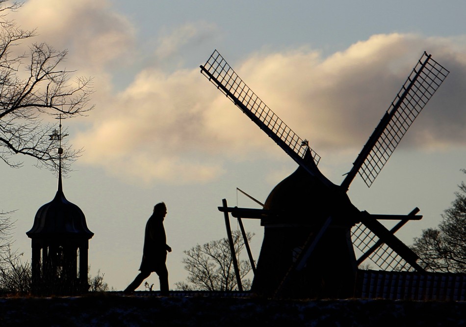 A man walks past a windmill in Kastellet park in Copenhagen