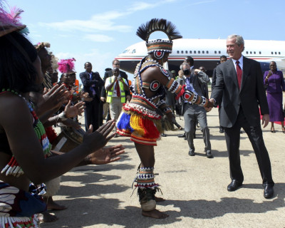 Former U.S. President Bush greets a traditional dancer on arrival at the Kenneth Kaunda International Airport in the capital Lusaka Former U.S. President Bush greets a traditional dancer on arrival at the Kenneth Kaunda International Airport in the capital Lusaka
