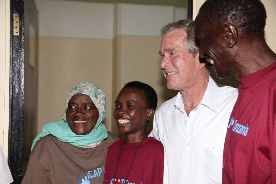 Former U.S. President George W. Bush and Tanzanian President Jakaya Kikwete pose for photographs with HIVAIDS and cancer patients as they visit Ocean Road Cancer Institute in Dar es Salaam