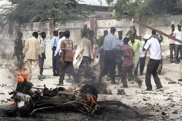 Somali police evacuate an injured colleague from the scene of a suicide car bomb near the KM4 building in Hodan district, south of the capital Mogadishu