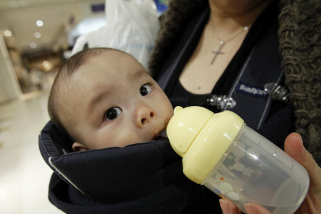 Miyako Ikeda feeds her baby Ryutaro drinking water after buying bottled water at a supermarket in Tokyo
