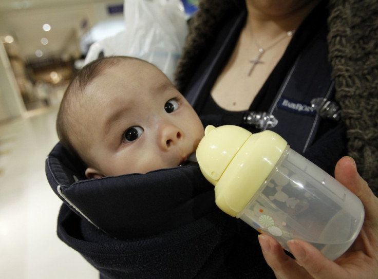 Miyako Ikeda feeds her baby Ryutaro drinking water after buying bottled water at a supermarket in Tokyo