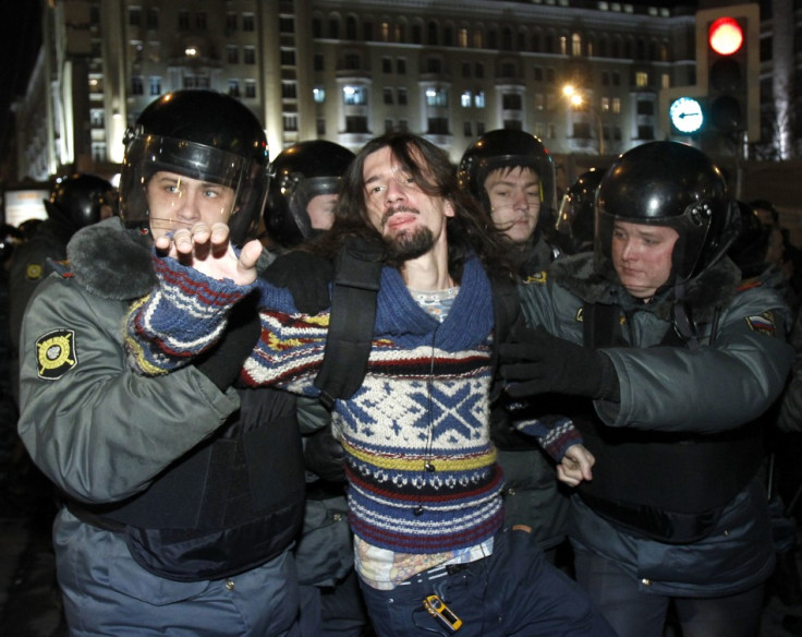 Policemen detain an activist during rally to protest against the results of the parliamentary elections