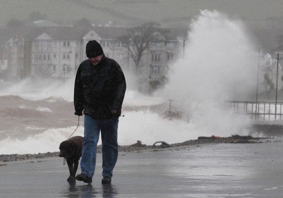 A man walks with his dog along promenade in Largs in west Scotland