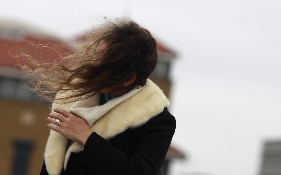 A woman s hair is blown across her face as she walks during a windy day in central London December 8, 2011.
