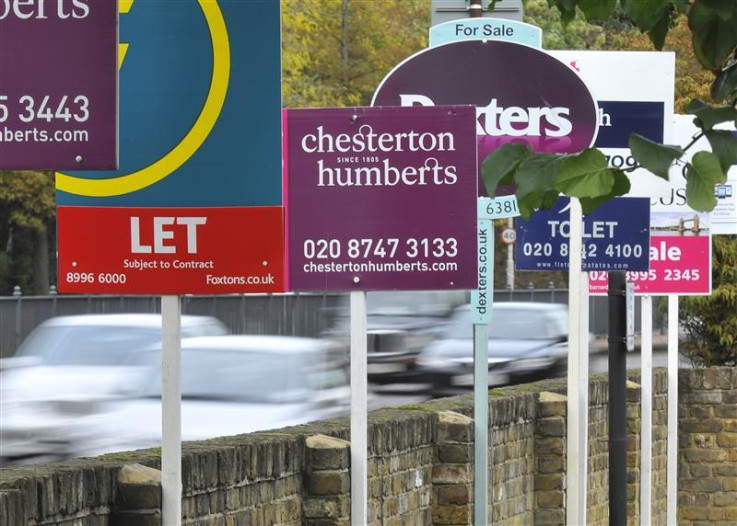 Cars pass property sales and letting signs in west London