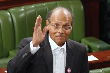Former doctor and human rights campaigner Moncef Marzouki waves to the media at the constituent assembly in Tunis