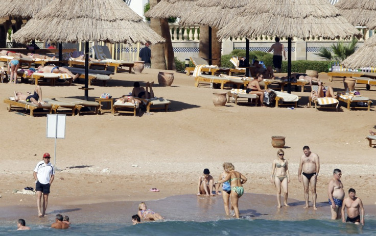 Tourists take a dip in the sea at a beach in the Red Sea resort city of Sharm el-Sheikh