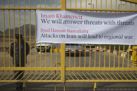 Security officer stands next to banner at the entrance of the Uranium Conversion Facility in Isfahan