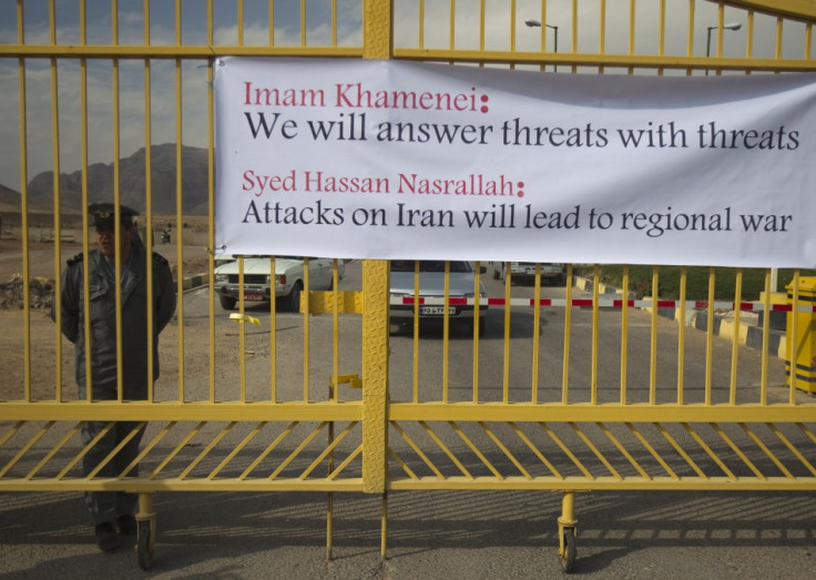 Security officer stands next to banner at the entrance of the Uranium Conversion Facility in Isfahan