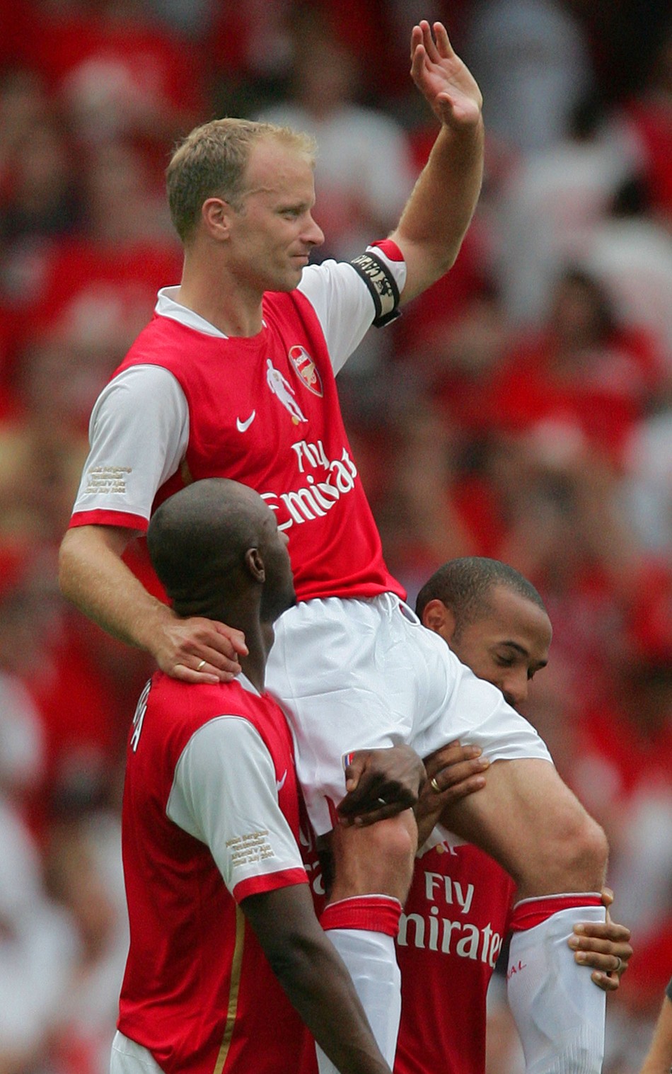 Arsenals Bergkamp carried by Viera and Henry at the Emirates Stadium after Arsenals friendly match against Ajax