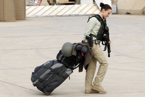 A member of U.S. security personnel pulls her luggage while waiting to depart from Iraq,