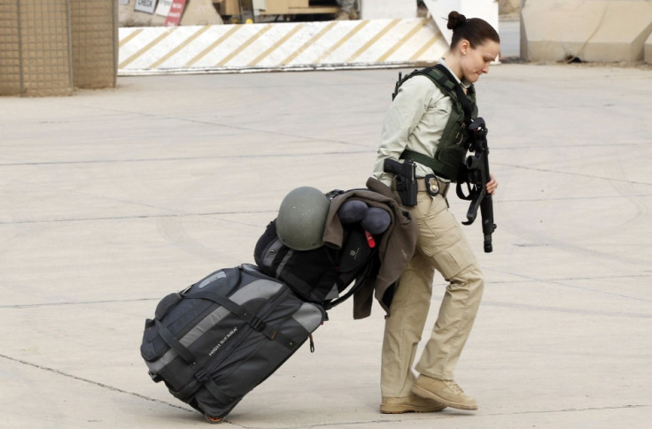 A member of U.S. security personnel pulls her luggage while waiting to depart from Iraq,