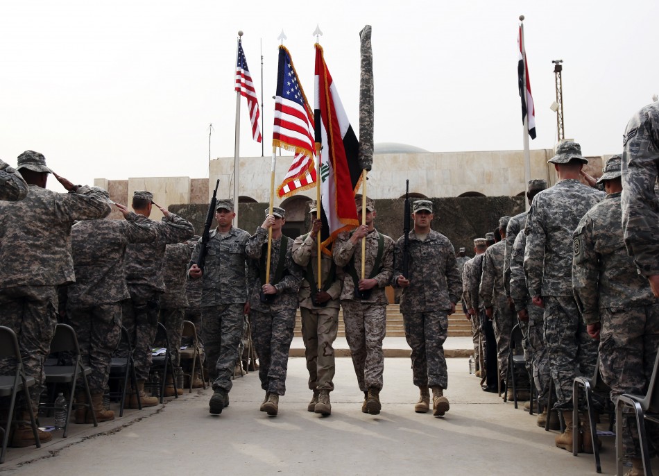 U.S. soldiers carry Iraqi national flag and U.S. flag during ceremony to retire flags, marking end of the U.S. military engagement at Baghdad Diplomatic Support Center