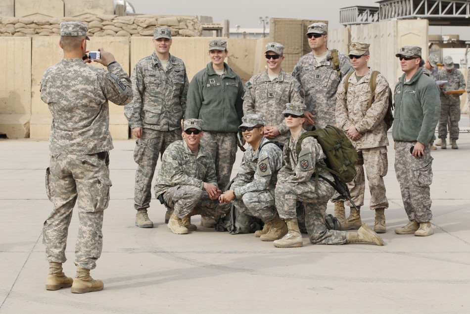US military personnel pose for a picture before the start of a ceremony marking the end of the U.S. military engagement, at the former US Sather Air Base