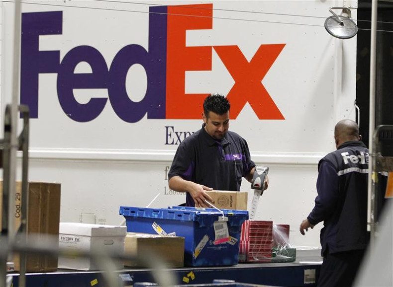 Handlers scan and affix a courier route label onto packages moving down the belt at the Marina Del Rey, California FedEx station