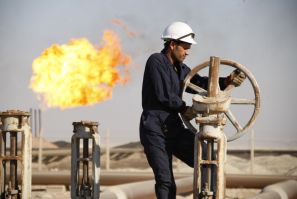A worker adjusts the valve of an oil pipe at West Qurna oilfield in Iraq's southern province of Basra November 28, 2010