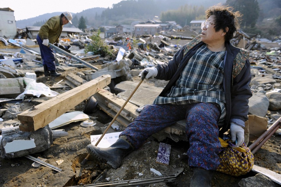 A woman looks out over the destroyed landscape in Ofunato City