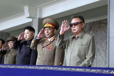 Kim Jong-il and his son Kim Jong-un salute as they watch soldiers attending a military parade