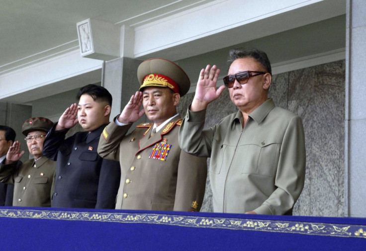 Kim Jong-il and his son Kim Jong-un salute as they watch soldiers attending a military parade