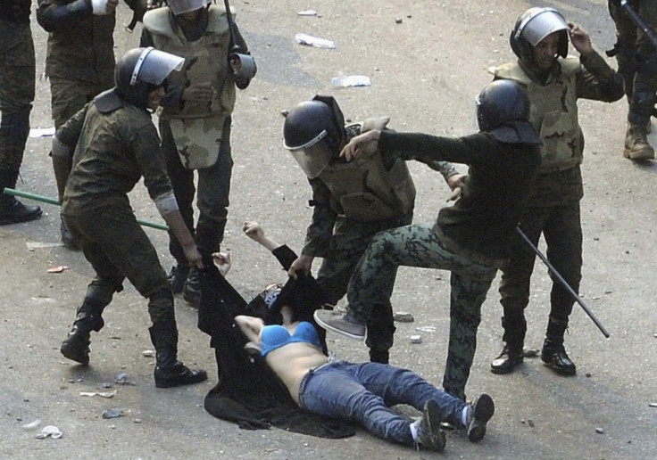 Egyptian army soldiers arrest a female protester during clashes at Tahrir Square in Cairo